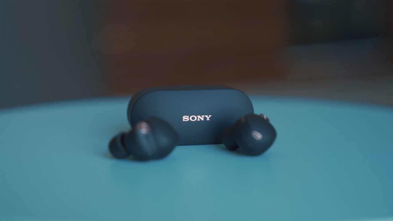 Des écouteurs sans-fil Sony sur un support bleu.