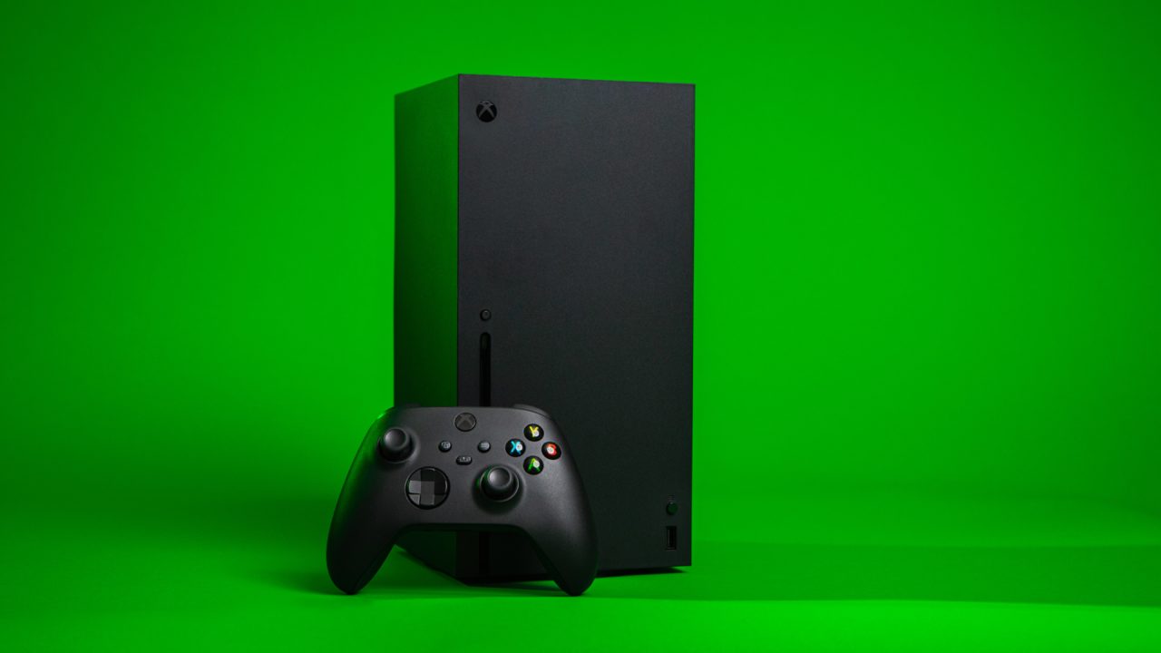 La Xbox Series X et une manette sur un fond vert.