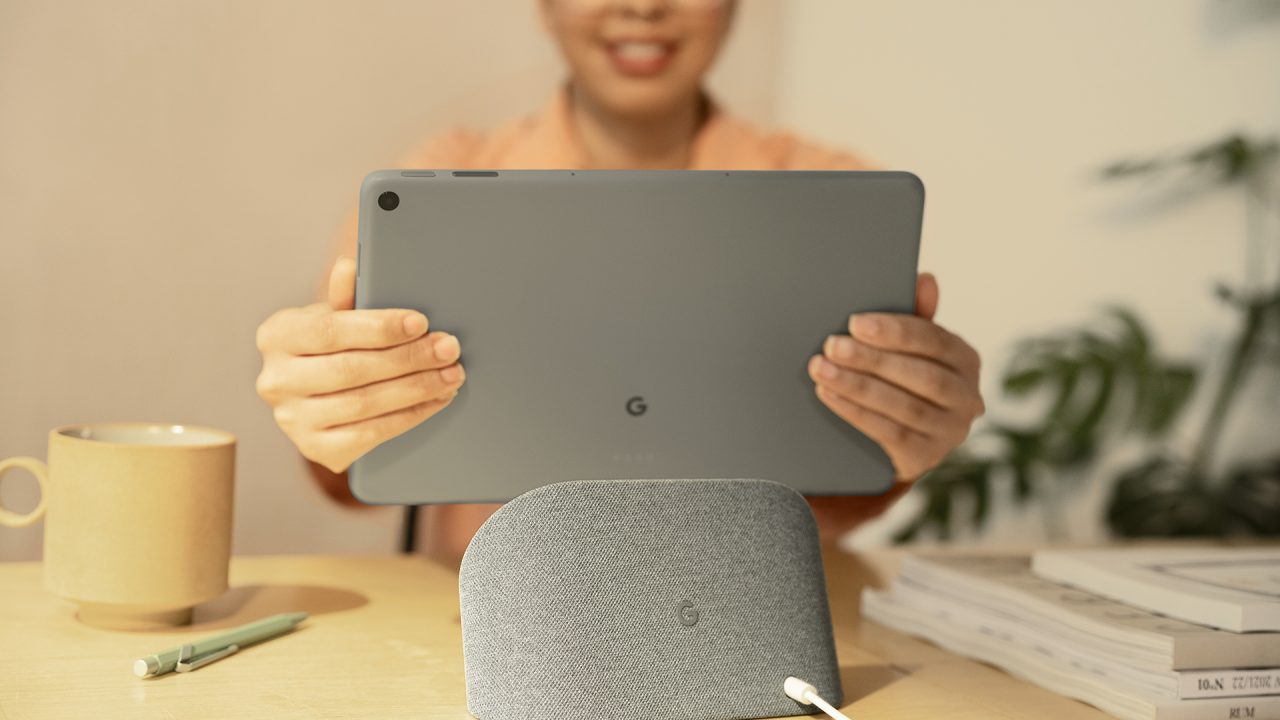 Image promotionnelle montrant une femme détachant la tablette Google Pixel Tablet de sa station de recharge
